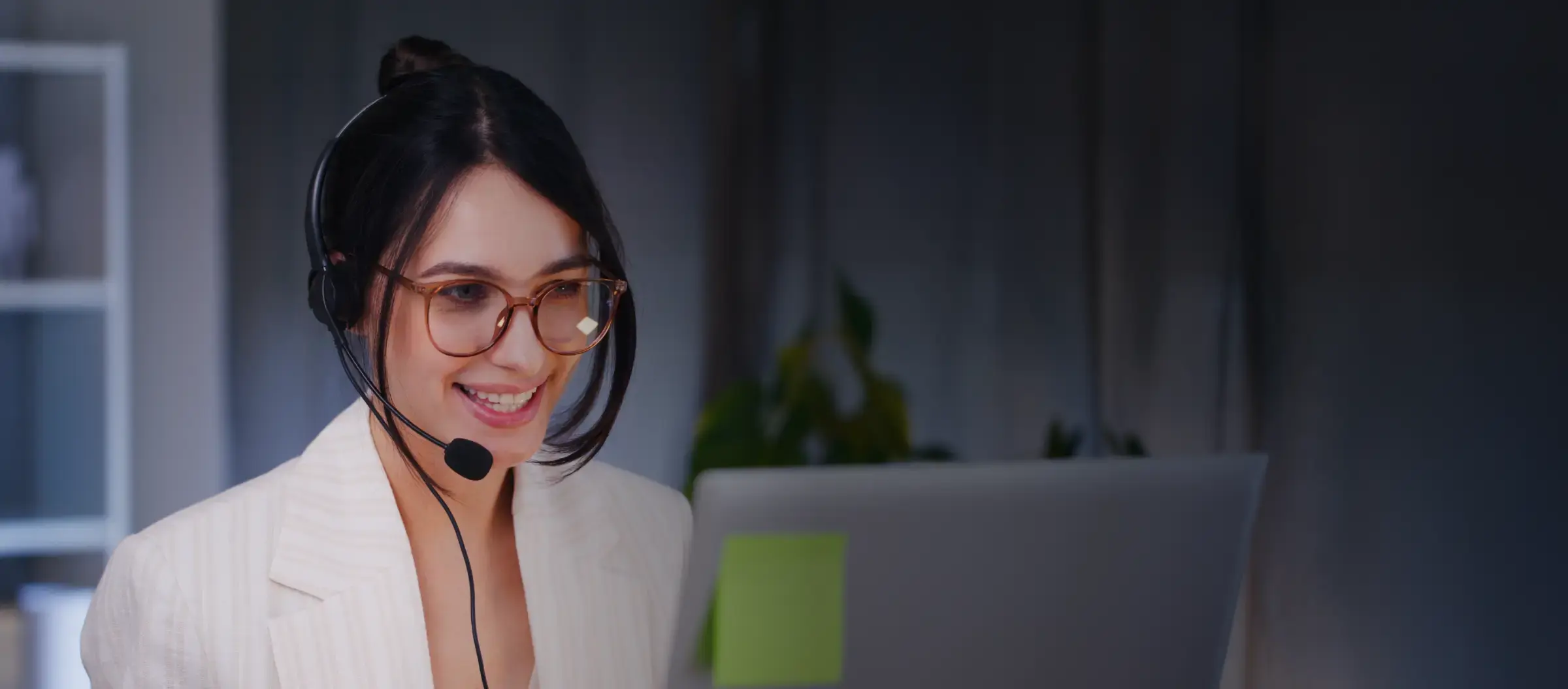 An admissions counselor wearing a headset at her laptop