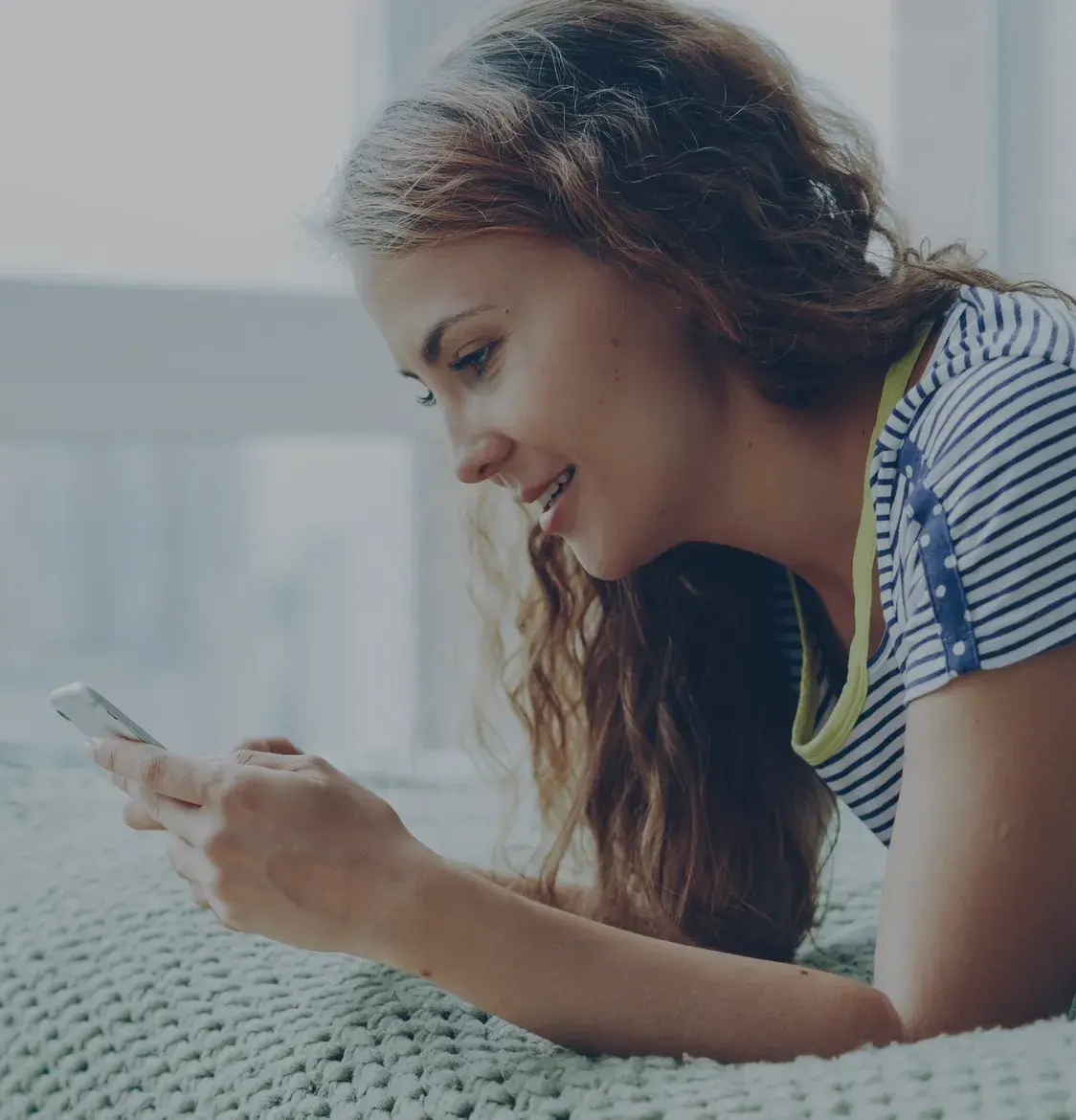 A woman smiling at her phone